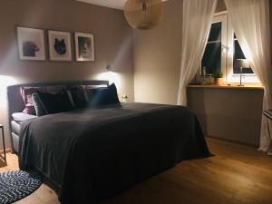 Un dormitorio con una cama negra y una ventana. en Schwedenvilla Estelle, en Dörphof
