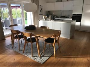 Una cocina con una mesa de comedor y sillas de madera. en Schwedenvilla Estelle, en Dörphof 20 fotos más