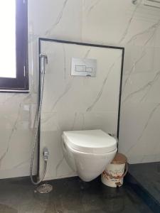 a white toilet in a bathroom with a shower at Guru Kripa House in Jodhpur