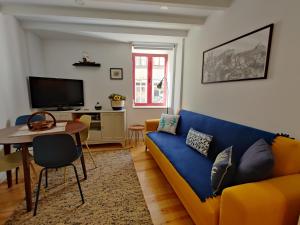 a living room with a blue couch and a table at Cais de Gaia Historic Loft in Vila Nova de Gaia