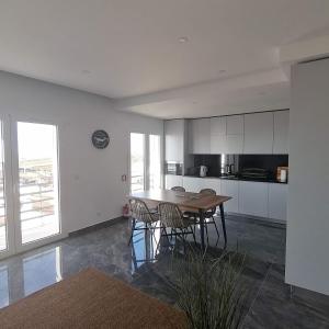 cocina con mesa de madera y algunas sillas en RIBEIRA D'ILHAS CENTRAL HOME, en Ericeira