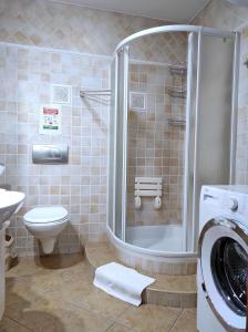 a bathroom with a shower and a washing machine at Apartamentylove - Apartament Oliwia in Zakopane