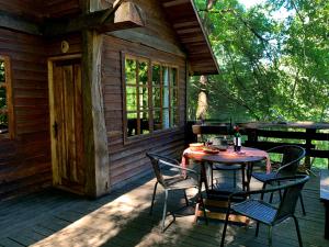 a table and chairs on the porch of a cabin at Corral del Agua in Curarrehue