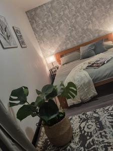 a bedroom with a bed and a potted plant at Wesermarsch, Apartment mit zwei Schlafzimmern, Gästehaus, Stedinger Landhotel in Berne