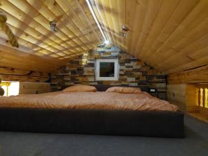 Cama grande en habitación con techo de madera en Apartment Mastnak, en Laško