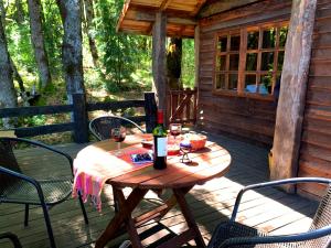 a wooden table with a bottle of wine on a deck at Corral del Agua in Curarrehue
