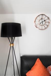 a black lamp and a clock on a white wall at Perfect For Business And Leisure- Free Parking in Southampton
