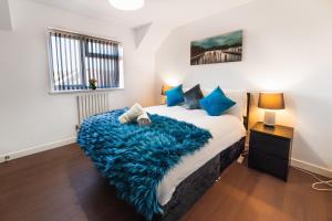 a bedroom with a bed with a blue blanket on it at Perfect For Business And Leisure- Free Parking in Southampton