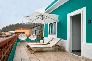 um pátio com duas cadeiras e um guarda-sol no telhado em Casa Salazar em Fuencaliente de la Palma