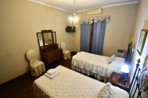 Habitación de hotel con 2 camas y espejo en Hostal El Cerrito en Salta