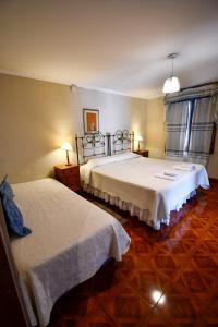 Habitación de hotel con 2 camas y 2 lámparas en Hostal El Cerrito en Salta