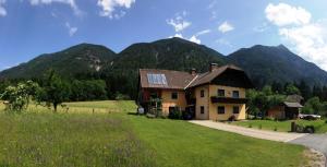 a house in a field with mountains in the background at Haus Berchtold in Hermagor