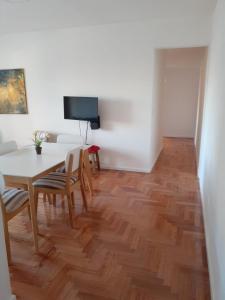 a dining room with a table and chairs and a television at Barracas 3 ambientes in Buenos Aires