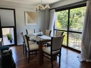 - une salle à manger avec une table et des chaises en bois dans l'établissement Leguizamon Plaza Deluxe, à Salta