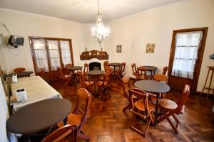 a dining room with tables and chairs and a fireplace at Hostal El Cerrito in Salta