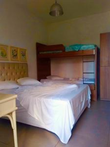 een slaapkamer met 2 bedden en een stapelbed bij Hotel Villa De Carli Beach in Rio Grande