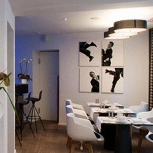 Hôtel Quatorze في كولمار: غرفة طعام مع طاولات بيضاء وكراسي بيضاء