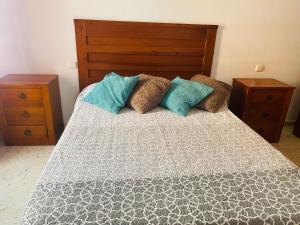 a bedroom with a bed with blue pillows and two night stands at SaVoa 869 in Gran Tarajal