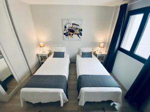 two beds in a small room with two windows at Apartamento de obra nueva cerca de la playa by Top Stay in El Médano