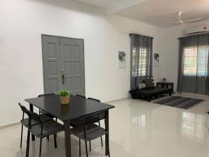 a black table and chairs in a living room at Impiana Homestay Jitra in Jitra