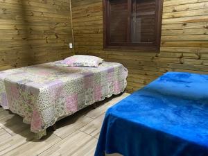 - une chambre avec 2 lits dans une cabane en bois dans l'établissement Cabana Bacana, à Praia Grande