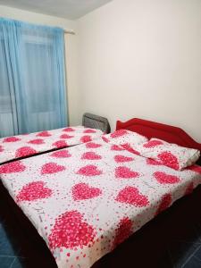 a bedroom with a bed with a red and white quilt at 2 bedroom Centre apartment in Podgorica