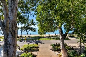 a park with trees and the beach in the background at Coral Horizons by Elysium Collection in Palm Cove