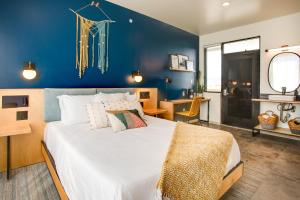 a bedroom with a large bed with a blue wall at The Monterey Motel in Albuquerque