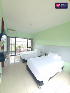 A bed or beds in a room at Hotel Griya Wijaya