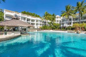 a swimming pool in front of a resort at Elysium The Beach Club in Palm Cove