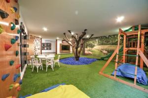 una habitación con un muro de escalada y un mural de árboles en Parque Pinares 2 dormitorios, en Pucón