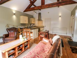 een woonkamer met een bank en een keuken bij Leadmill House Workshop in Copley