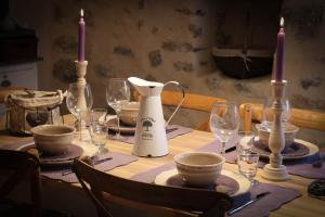 - une table à manger avec des bougies et des verres à vin dans l'établissement Gite Marceline, à Saint-Guilhem-le-Désert