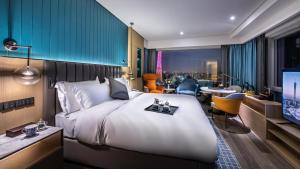 una camera con un grande letto e una TV di Guangzhou Elegant Hotel a Canton