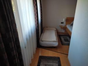 ein kleines Zimmer mit einem kleinen Bett und einem kleinen Fenster in der Unterkunft Ferienwohnung Marietta Mair in Haiming