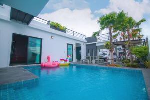 a house with a swimming pool with a pink float in it at บ้าน Spring Vintage Pool Villa ใจกลางเมืองหัวหิน ใกล้หาด in Hua Hin