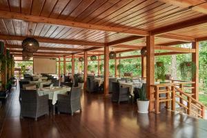 a restaurant with tables and chairs and a screen at Grand M Hotel in Navoi