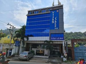 Un alto edificio blu con un cartello sopra di Vijay Shree Inn a Vellore