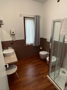 a bathroom with two sinks and a toilet and a shower at Relais Villa Rosa in Pero