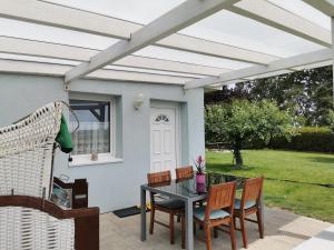 Bungalow 4 Pers. في Elmenhorst: ممر على فناء مع طاولة وكراسي