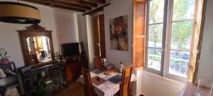 a living room with a table and a window at A appartement Cozy, vue sur le port, gîte, les pieds dans l'eau in Sablé-sur-Sarthe