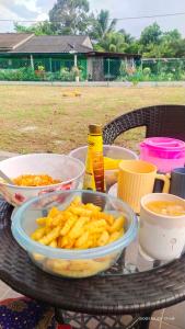 a table with a bowl of food and a bowl of fries at Homestay De'69 in Jitra