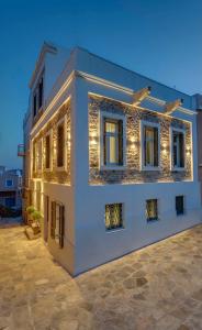 a white house with lights on the side of it at Amare Boutique Suites in Ermoupoli