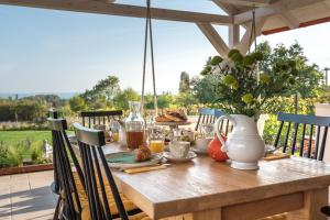 - une table en bois avec de la nourriture et des boissons sur la terrasse dans l'établissement Lovassy Lodge Vendégház, à Lovas