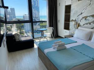 Apartment In Porta Batumi Tower في باتومي: غرفة نوم بسرير وإطلالة على المدينة