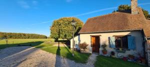 a small white house with a tree next to it at La duvallerie chambre d hôte in Cangey