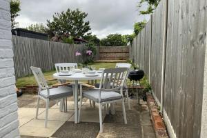 a table and chairs on a patio with a fence at Boutique City Centre Home in Chichester