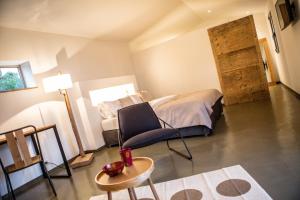 a bedroom with a bed and a chair and a table at Hotel Les Chambres de Mila in Bonifacio