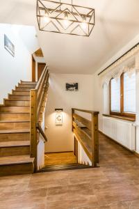 a staircase in a home with wooden floors and a chandelier at Apartamenty Harenda Ski in Zakopane