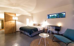 a bedroom with a bed and a table and a chair at Hotel Les Chambres de Mila Bonifacio in Bonifacio